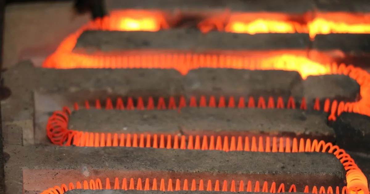 PEEK vs Vespel at high temperature: a glowing red electric heating element coil set in a furnace